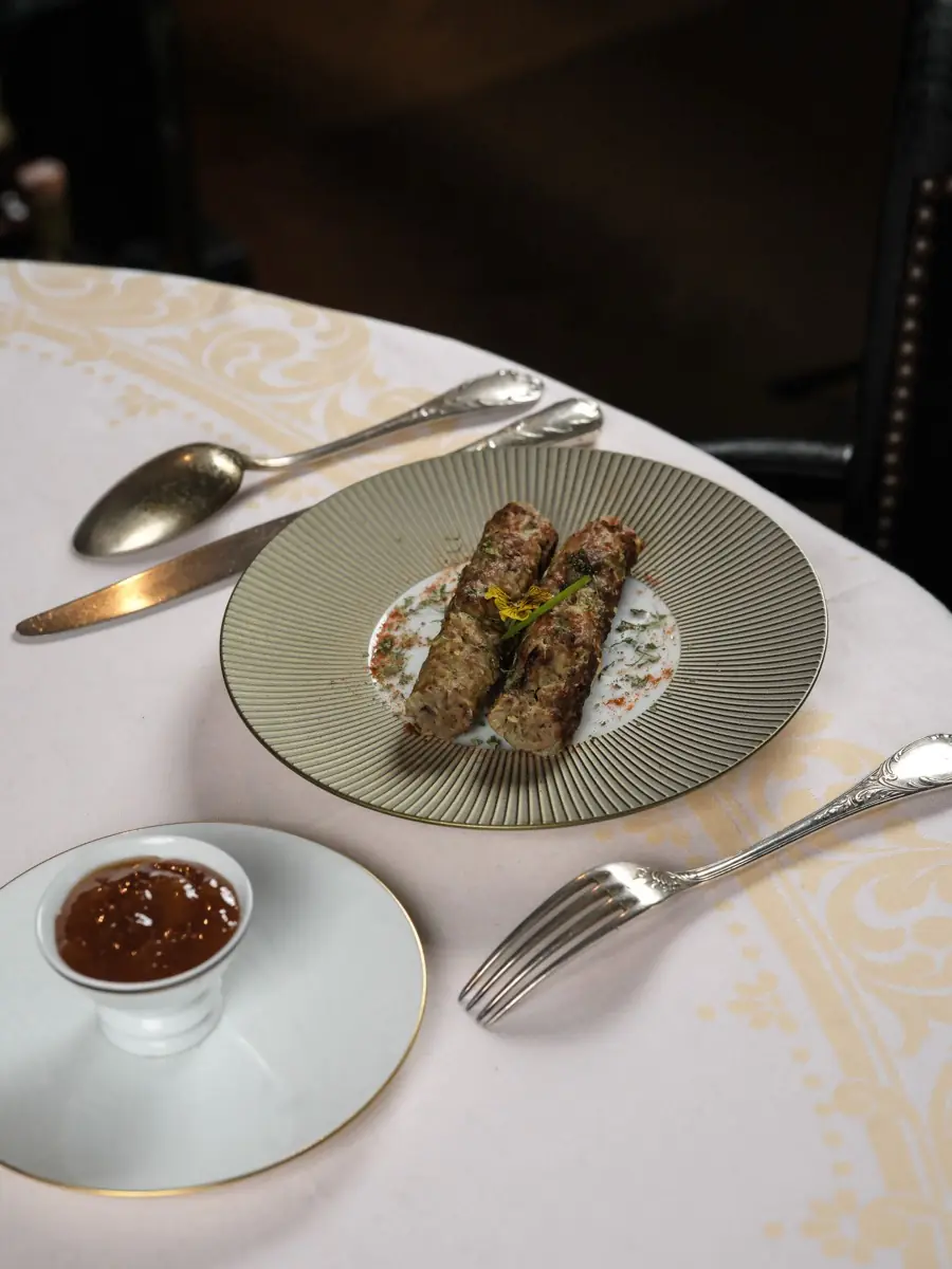 Seekh kebab and tamarind chutney on a porcelain plate