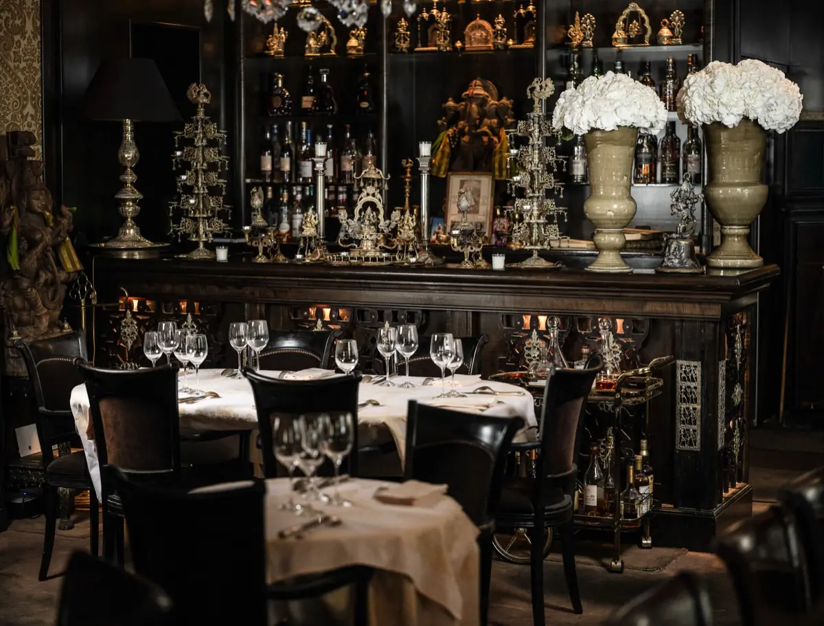 The dining room with laid tables beneath gilded cabinets